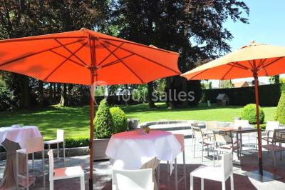 Salle de réception lumineuse avec bar central circulaire, tables hautes et éclairage coloré.