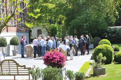 Salle de réception lumineuse avec bar central circulaire, tables hautes et éclairage coloré.