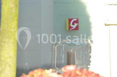 Salle de réception lumineuse avec bar central circulaire, tables hautes et éclairage coloré.