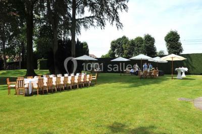 Salle de réception lumineuse avec bar central circulaire, tables hautes et éclairage coloré.