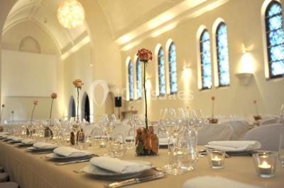 Salle de réception lumineuse avec bar central circulaire, tables hautes et éclairage coloré.