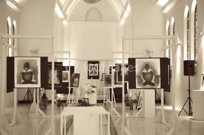 Salle de réception lumineuse avec bar central circulaire, tables hautes et éclairage coloré.
