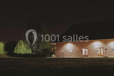 Table élégamment dressée avec nappes blanches, vaisselle raffinée, bougies allumées et décoration florale.