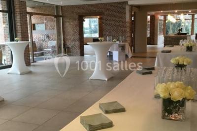 Table élégamment dressée avec nappes blanches, vaisselle raffinée, bougies allumées et décoration florale.