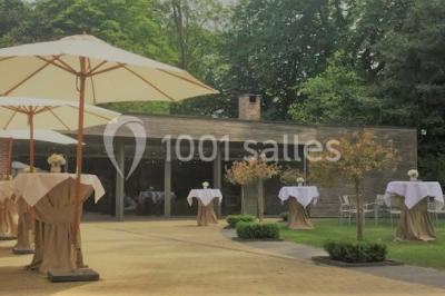 Table élégamment dressée avec nappes blanches, vaisselle raffinée, bougies allumées et décoration florale.