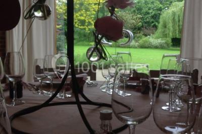 Table élégamment dressée avec nappes blanches, vaisselle raffinée, bougies allumées et décoration florale.