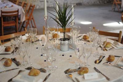 Deux lits simples avec couvertures vertes dans une chambre mansardée aux poutres apparentes et murs en plâtre.