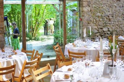 Deux lits simples avec couvertures vertes dans une chambre mansardée aux poutres apparentes et murs en plâtre.