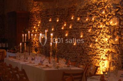 Deux lits simples avec couvertures vertes dans une chambre mansardée aux poutres apparentes et murs en plâtre.