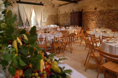 Deux lits simples avec couvertures vertes dans une chambre mansardée aux poutres apparentes et murs en plâtre.