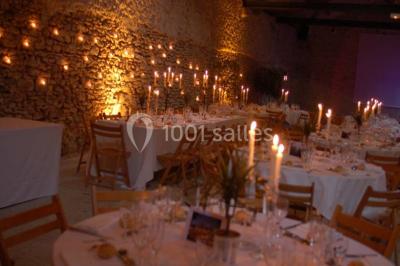 Deux lits simples avec couvertures vertes dans une chambre mansardée aux poutres apparentes et murs en plâtre.