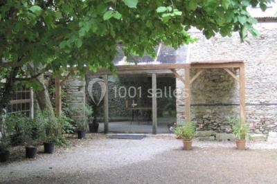 Deux lits simples avec couvertures vertes dans une chambre mansardée aux poutres apparentes et murs en plâtre.