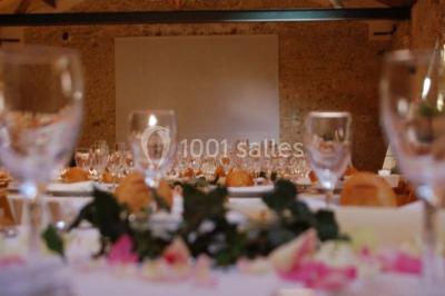 Deux lits simples avec couvertures vertes dans une chambre mansardée aux poutres apparentes et murs en plâtre.