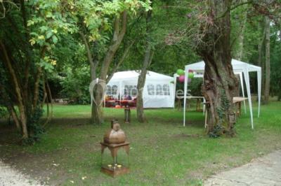 Deux lits simples avec couvertures vertes dans une chambre mansardée aux poutres apparentes et murs en plâtre.