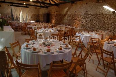 Deux lits simples avec couvertures vertes dans une chambre mansardée aux poutres apparentes et murs en plâtre.