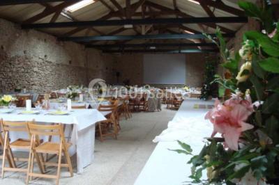 Deux lits simples avec couvertures vertes dans une chambre mansardée aux poutres apparentes et murs en plâtre.