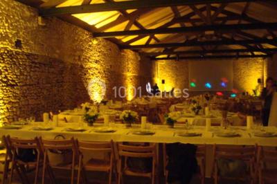 Deux lits simples avec couvertures vertes dans une chambre mansardée aux poutres apparentes et murs en plâtre.