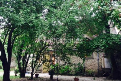 Deux lits simples avec couvertures vertes dans une chambre mansardée aux poutres apparentes et murs en plâtre.