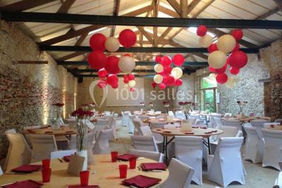 Deux lits simples avec couvertures vertes dans une chambre mansardée aux poutres apparentes et murs en plâtre.