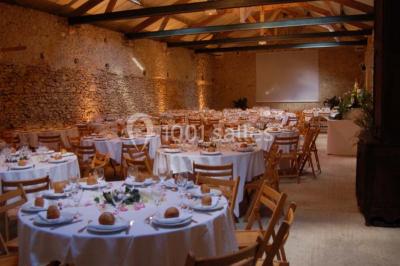 Deux lits simples avec couvertures vertes dans une chambre mansardée aux poutres apparentes et murs en plâtre.