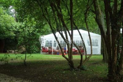 Deux lits simples avec couvertures vertes dans une chambre mansardée aux poutres apparentes et murs en plâtre.