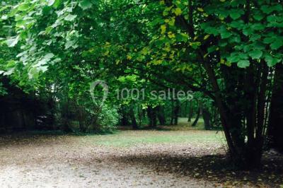 Deux lits simples avec couvertures vertes dans une chambre mansardée aux poutres apparentes et murs en plâtre.