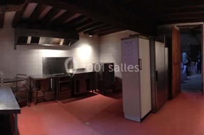 Deux lits simples avec couvertures vertes dans une chambre mansardée aux poutres apparentes et murs en plâtre.