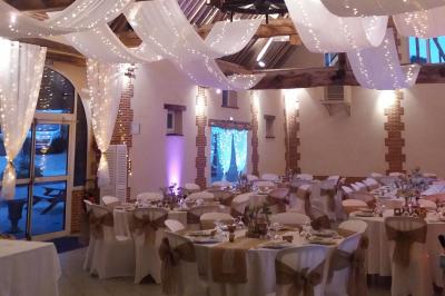 Jardin avec bancs, tables en bois et un pigeonnier en arrière-plan sous un ciel nuageux.