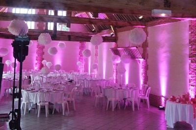 Jardin avec bancs, tables en bois et un pigeonnier en arrière-plan sous un ciel nuageux.
