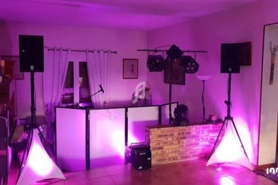 Installation de matériel de sonorisation et éclairage dans une pièce avec murs clairs et décoration sobre.