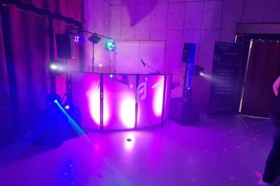 Éclairage coloré et équipement de sonorisation installés dans une salle pour un événement festif.