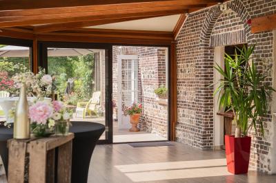 Miniature Location salle La Cerlangue (Seine-Maritime) - Le Clos du Meslay #8 Centre de table avec roses blanches et fleurs dans un vase en verre rond, sur une nappe en toile de jute.
