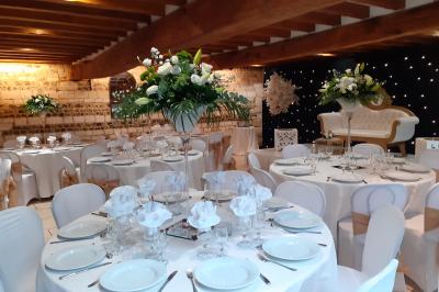 Miniature Location salle La Cerlangue (Seine-Maritime) - Le Clos du Meslay #2 Centre de table avec roses blanches et fleurs dans un vase en verre rond, sur une nappe en toile de jute.