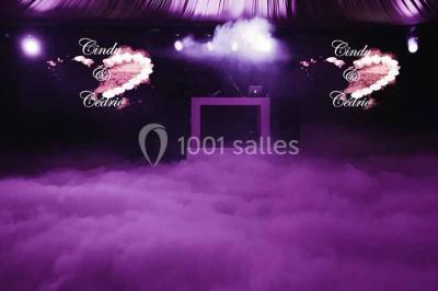 Une mariée lance son bouquet à un groupe de femmes rassemblées dans un jardin lors d'une réception en soirée.