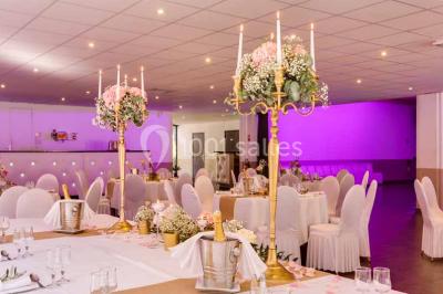 Une mariée lance son bouquet à un groupe de femmes rassemblées dans un jardin lors d'une réception en soirée.