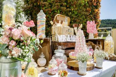 Une mariée lance son bouquet à un groupe de femmes rassemblées dans un jardin lors d'une réception en soirée.