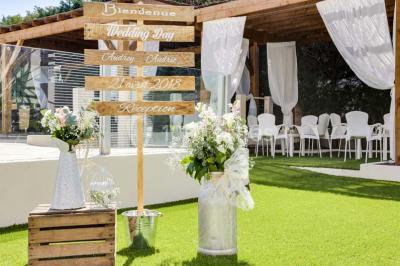 Une mariée lance son bouquet à un groupe de femmes rassemblées dans un jardin lors d'une réception en soirée.