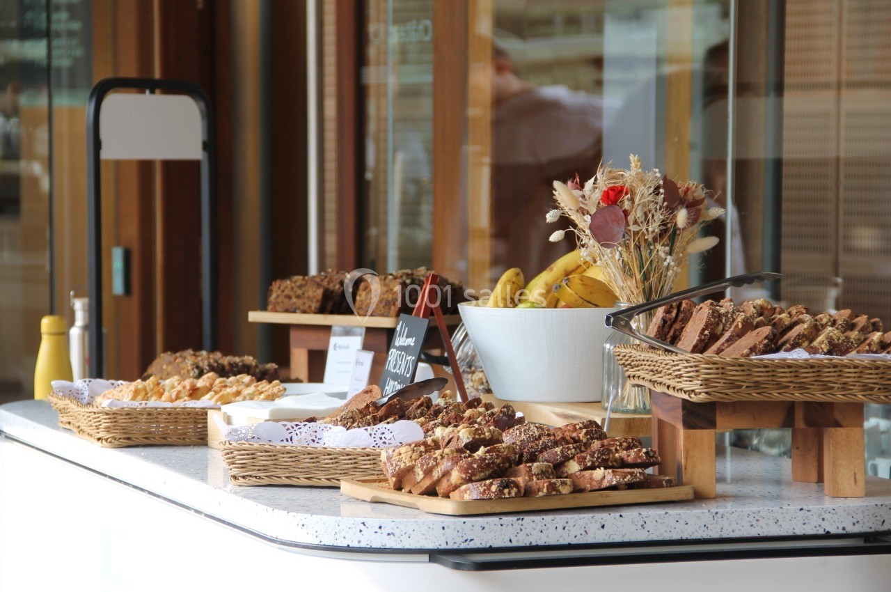 Stand de viennoiseries et pâtisseries variées présentées dans des paniers en osier sur un comptoir.