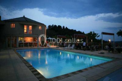 Vue aérienne d'un complexe avec piscine, toboggan aquatique, mini-golf et espaces ombragés entourés de végétation.