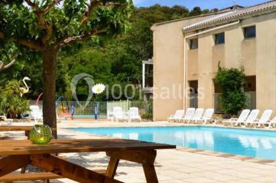 Vue aérienne d'un complexe avec piscine, toboggan aquatique, mini-golf et espaces ombragés entourés de végétation.