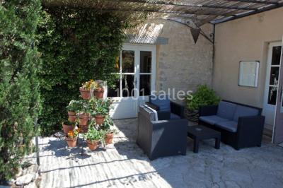 Montagne rocheuse éclairée par une lumière douce, entourée de collines boisées et d'arbres au premier plan.