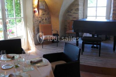 Montagne rocheuse éclairée par une lumière douce, entourée de collines boisées et d'arbres au premier plan.