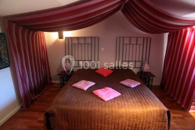 Montagne rocheuse éclairée par une lumière douce, entourée de collines boisées et d'arbres au premier plan.