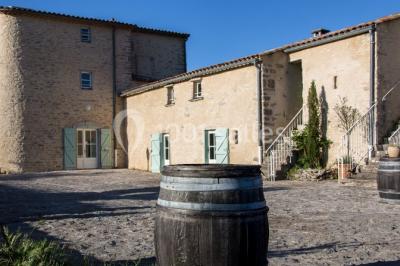 Montagne rocheuse éclairée par une lumière douce, entourée de collines boisées et d'arbres au premier plan.