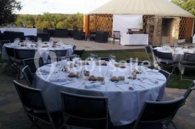 Montagne rocheuse éclairée par une lumière douce, entourée de collines boisées et d'arbres au premier plan.
