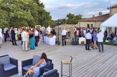 Montagne rocheuse éclairée par une lumière douce, entourée de collines boisées et d'arbres au premier plan.