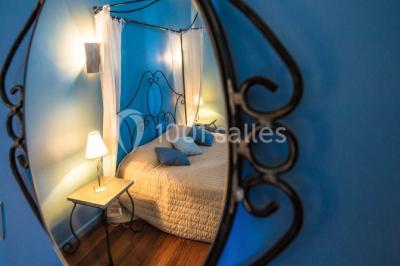 Montagne rocheuse éclairée par une lumière douce, entourée de collines boisées et d'arbres au premier plan.