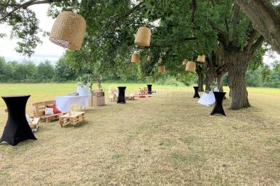Chemin de gravier menant à une maison en pierre avec toit en tuiles, entourée de verdure et d'une clôture en bois.