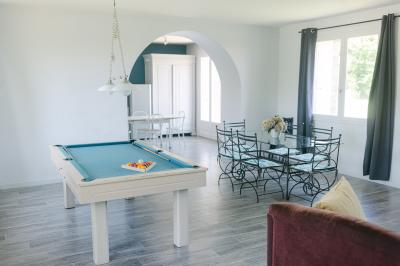 Chemin de gravier menant à une maison en pierre avec toit en tuiles, entourée de verdure et d'une clôture en bois.