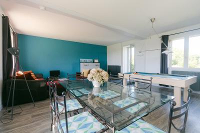 Chemin de gravier menant à une maison en pierre avec toit en tuiles, entourée de verdure et d'une clôture en bois.